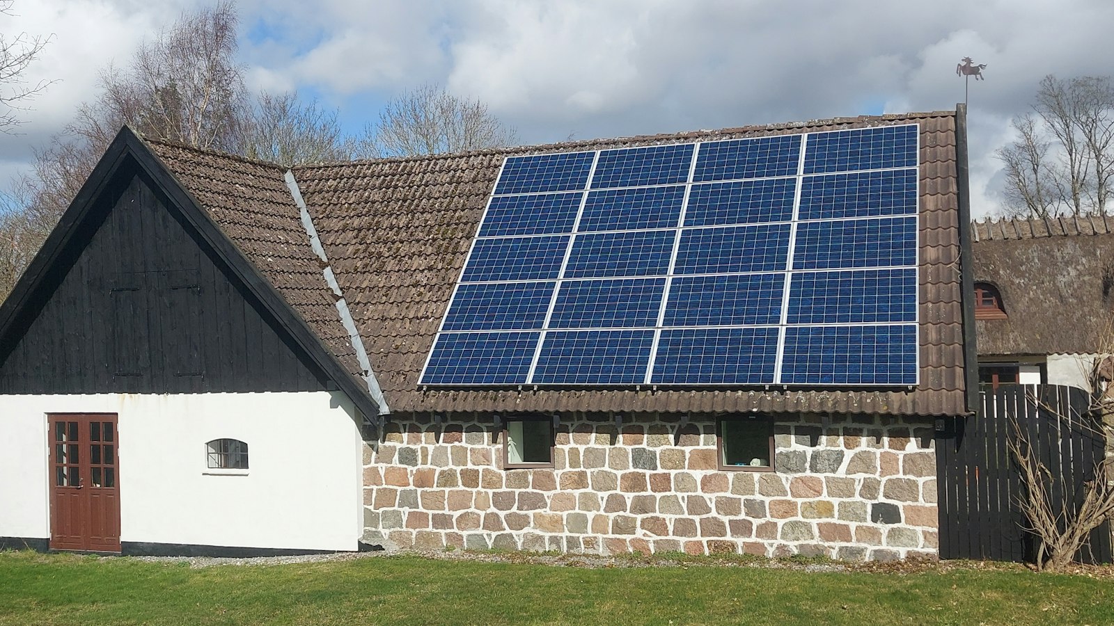 Maison au toit de tuiles équipé de panneaux photovoltaïques